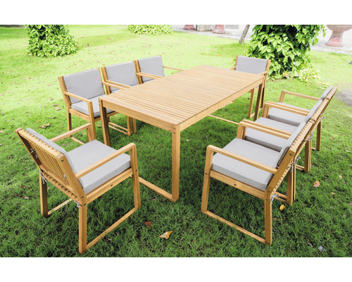 Gartentisch mit sechs Stühlen aus Holz mit hellen Sitzkissen auf Rasen