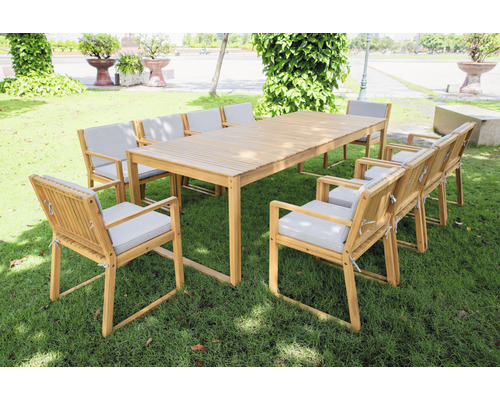 Gartenszene mit einem Esstisch aus Holz und acht Stühlen mit Sitzkissen auf einem Rasen