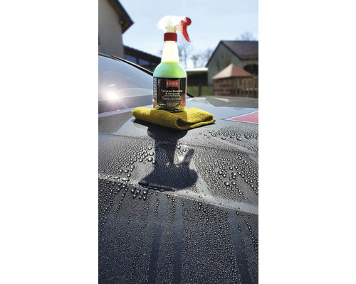 Spray de nettoyage et chiffon sur une surface de véhicule humide