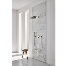 Ensemble de douche avec douche de tête, douchette à main et robinetterie sur un mur en marbre dans une salle de bain lumineuse.