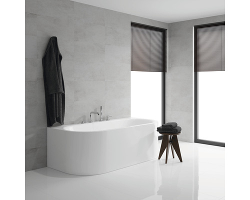Salle de bains lumineuse avec baignoire, fenêtres avec stores et tabouret avec serviettes