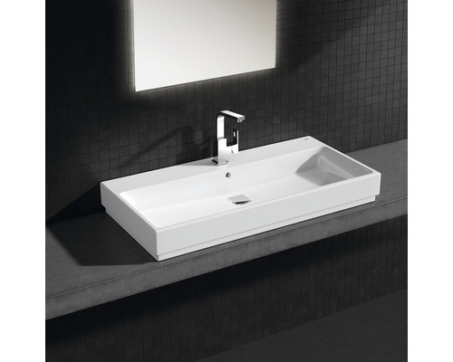 Vasque rectangulaire en céramique avec robinetterie et miroir sur mur sombre