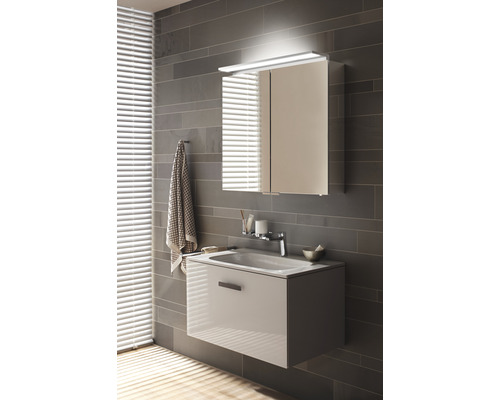 Salle de bains moderne avec meuble sous-lavabo et armoire de toilette avec éclairage sur un mur gris.