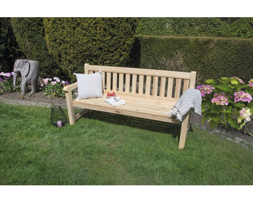 Scène de jardin avec banc en bois, coussin et décoration