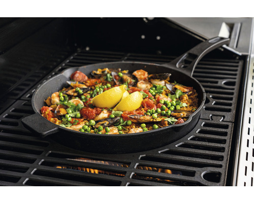 Paella dans une poêle à frire préparée sur un gril