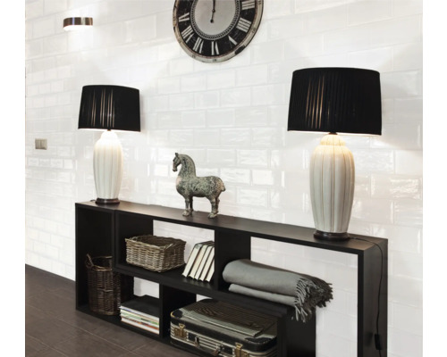 Wohnraum mit schwarzen Regalen, Tischlampen und weißen Wandfliesen im Retro-Stil