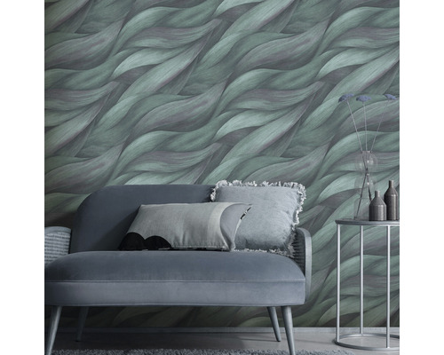 Salon avec canapé, table d''appoint et papier peint vert à motif ondulé