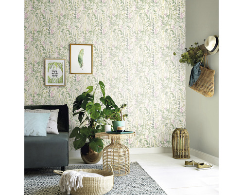 Wohnzimmer mit Couch, Beistelltisch, Zimmerpflanzen, Dekoration und Tapete mit Pflanzenmuster.