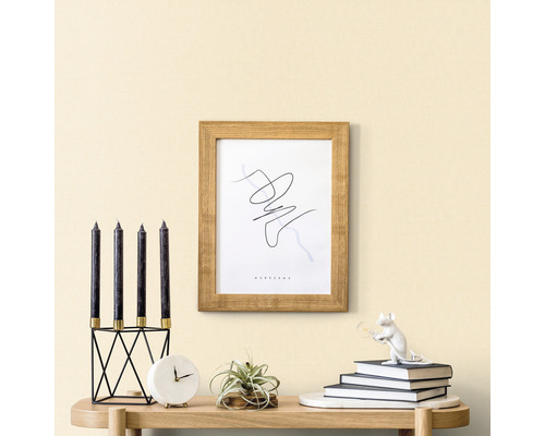 Scène décorative avec bougies, horloge, plante, cadre et figurine décorative sur une table