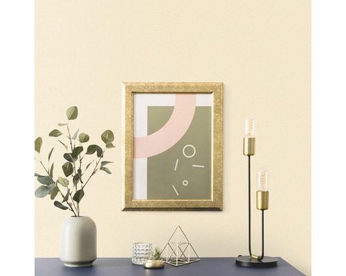 Arrangement décoratif avec une image encadrée, un vase avec de l''eucalyptus, un photophore, une décoration et une lampe de table sur une table