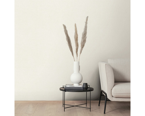 Dekorative Federn in einer weißen Vase auf einem schwarzen Beistelltisch neben einem Sofa