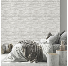 Schlafzimmer mit Bett vor einer hellen Wandtapete mit Wellenmuster