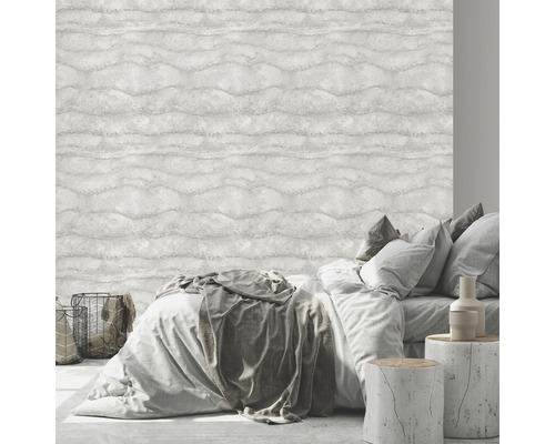 Schlafzimmer mit Bett vor einer hellen Wandtapete mit Wellenmuster