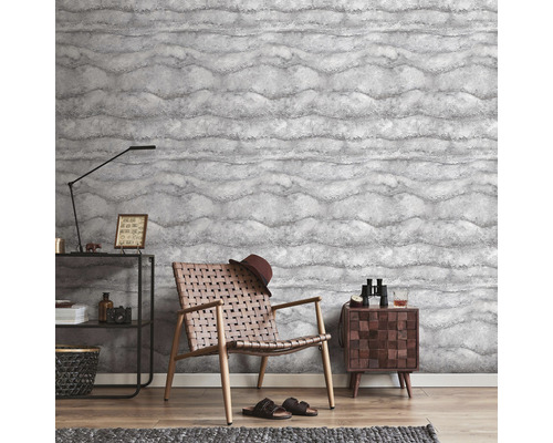 Salon avec papier peint à motifs, fauteuil et table d''appoint.