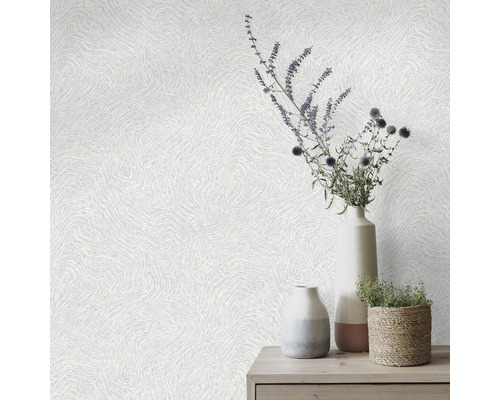 Dekorative Tapete mit gewelltem Muster und Vasen mit Blumenarrangement auf einem Tisch