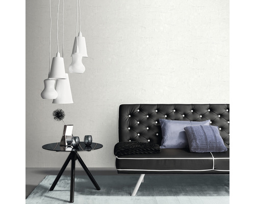 Intérieur d''une pièce avec un canapé noir à boutons, une table noire, des décorations et plusieurs lampes blanches