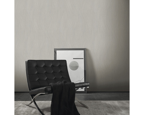 Helle Wand mit Struktur neben einem Sessel und einem Bild