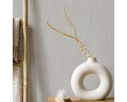 Helle Wohnraumgestaltung mit einer Dekovase und einem Bambusregal vor einer gemusterten Wand