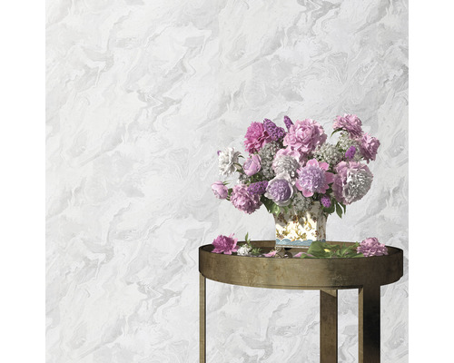 Wand mit Marmortapete und Tisch mit Blumen