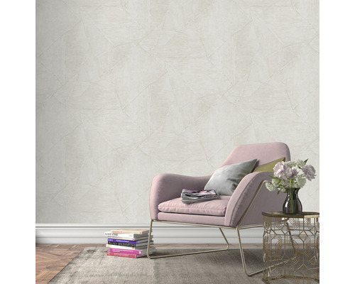 Scène avec un mur avec du papier peint intissé aspect pierre, un fauteuil, une table d''appoint et des décorations pour une ambiance chaleureuse.