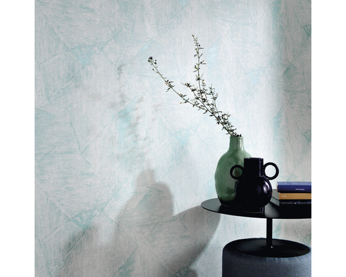 Gros plan d''un mur avec du papier peint structuré, une table d''appoint avec décoration et un tabouret.