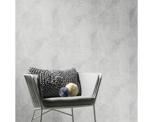 Eine helle Wand mit geometrischem Muster und ein Stuhl mit Kissen und Zierkugeln.