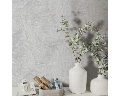 Szene mit gemusterter Tapete, Vasen und Dekorationsgegenständen auf einem Tisch