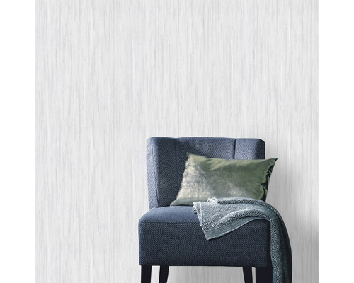 Papier peint intissé clair dans une pièce avec fauteuil, coussin et couverture