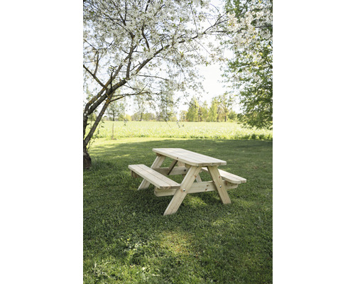 Table de pique-nique en bois dans un jardin sous un arbre en fleurs