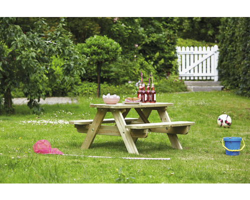 Table de pique-nique en bois dans le jardin avec des boissons et des collations