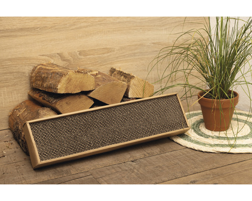 Kratzbrett aus Karton für Katzen, neben Holzscheiten und Zimmerpflanze