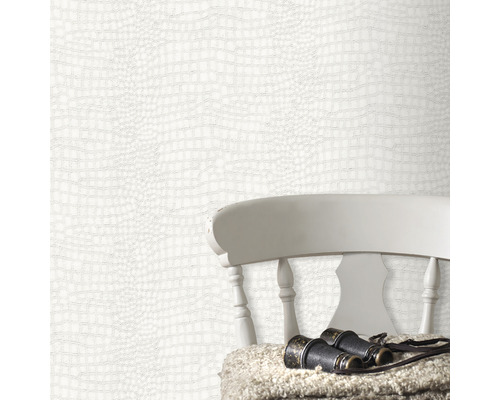 Tapete mit Krokodilleder-Optik im Arrangement mit Stuhl und Fernglas