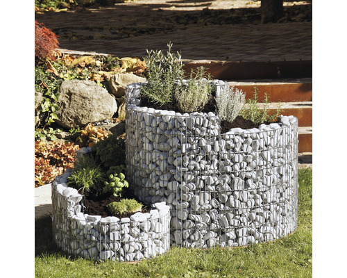 Dreistufige Gabionen Kräuterspirale im Garten.