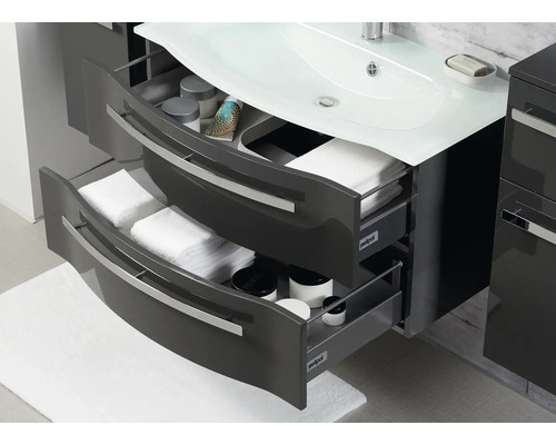 Badezimmerunterschrank mit Waschbecken und offenen Schubladen zur Aufbewahrung von Handtüchern und Kosmetikartikeln.