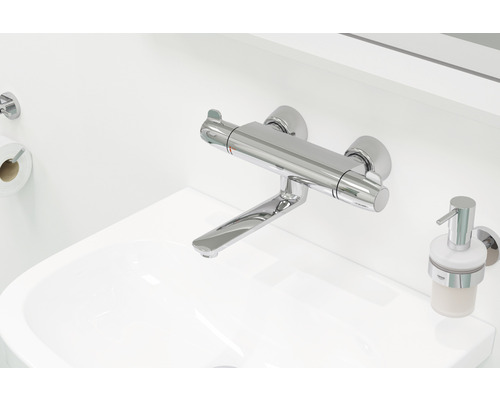 Image d''un lavabo avec robinet, distributeur de savon et porte-papier toilette
