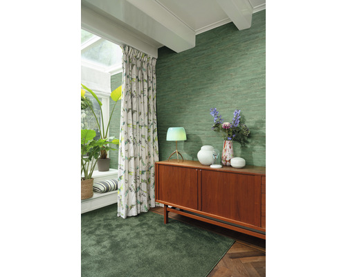 Salon avec papier peint textile vert, tapis, rideaux et buffet en bois