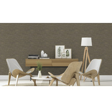 Wohnzimmer mit brauner Tapete, zwei Sesseln und einer Kommode mit Dekoration