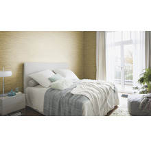 Schlafzimmer mit Bett, Nachttisch und goldfarbener Wandtapete.