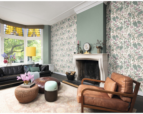 Salon lumineux avec papier peint à motifs floraux, cheminée et meubles en cuir pour une ambiance chaleureuse