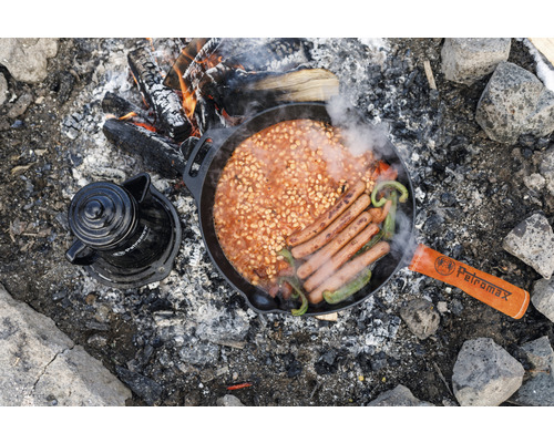 Scène de feu de camp avec des haricots, des saucisses et une cafetière dans une poêle au-dessus du feu