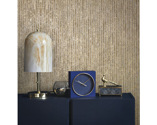 Dekorative Szene mit Lampe, Uhr und Ornamenten auf einem Sideboard vor einer strukturierten Wand