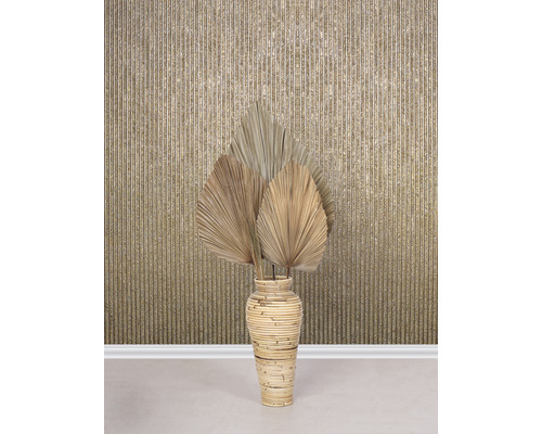 Dekorative getrocknete Palmblätter in einer Bambusvase vor einer Wand mit Streifenmuster.