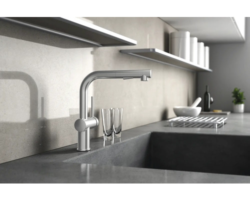 Robinet de cuisine en métal sur un comptoir de cuisine avec des verres et des étagères