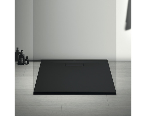 Receveur de douche noir avec garniture d''écoulement dans la salle de bain.