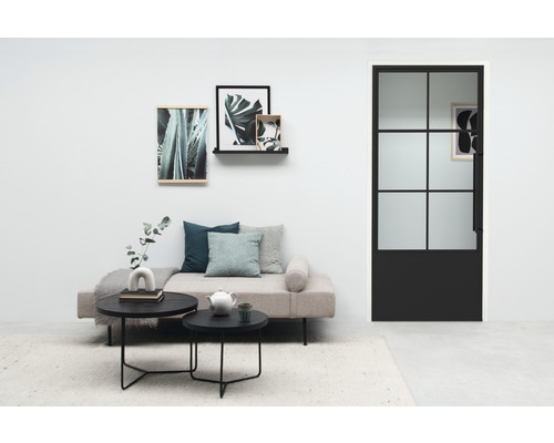 Wohnzimmer mit Tagesbett, Couchtischen und schwarzer Innentür mit Glaseinsatz