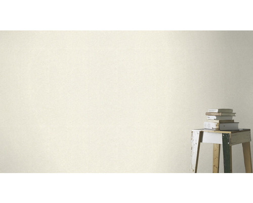 Nahaufnahme einer Wandtapete mit dezenter Musterung neben einem Stapel Bücher auf einem Hocker