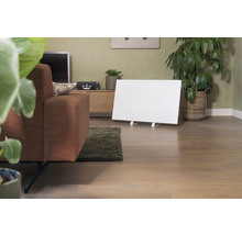 Wohnzimmer mit Sofa, Zimmerpflanzen, Kommode und einem weißen Infrarot Heizpaneel.