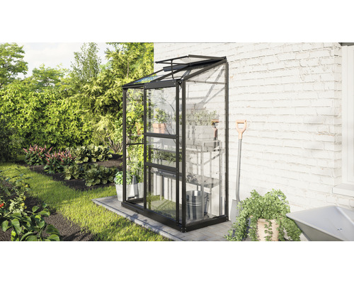 Gewächshaus mit Regalen und Gartenzubehör an einer Hauswand