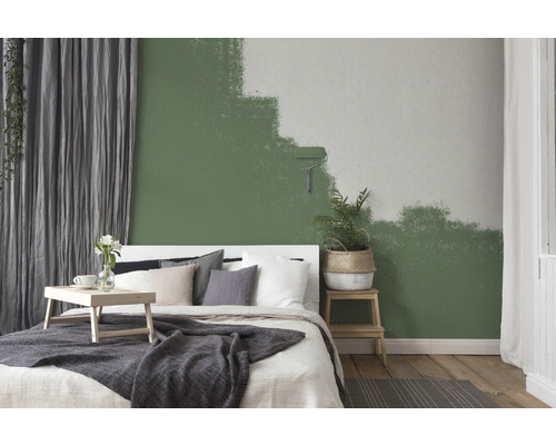 Schlafzimmer mit grün gestrichener Wand und Farbroller