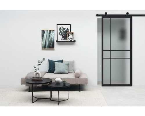 Wohnzimmer mit Sofa, Couchtischen, Wanddekoration und Schiebetür